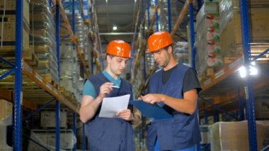 Genç ambar çalışanı bir iş deneyimleri arkadaşından eğilir.