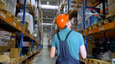 Arkadan Görünüm bir depolama koridor yürüme bir ambar çalışanı üzerinde. 4k.