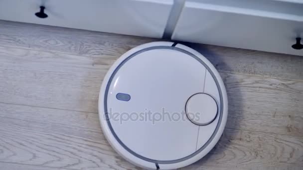 En robotic vacuum rör sig längs vita lådor i ett smart hus. 4k. — Stockvideo