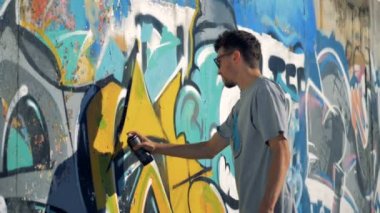 Bir graffitist bir duvar siyah kontür yeniler.