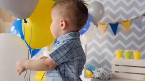 Un bambino felice sorride circondato da palloncini . — Video Stock