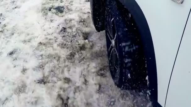 Het wiel van de auto glijdt in de sneeuw. 4k. — Stockvideo