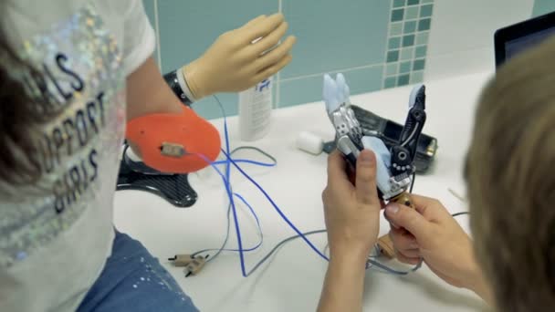 Lány használata bionikus 3d nyomtatott kar az első alkalommal. Robotkaros végtagok, protézis. — Stock videók