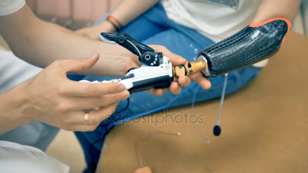 Роботизированная конечность, протез. Девушка впервые пользуется бионической 3D-печатью руки. 4K . — стоковое видео
