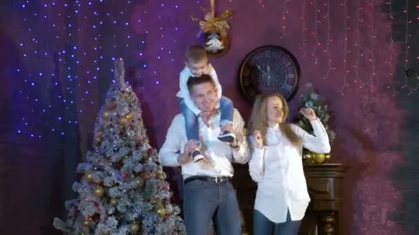 Genç anne ve çocuk danslarının yakınındaki bir Noel ağacı. — Stok video