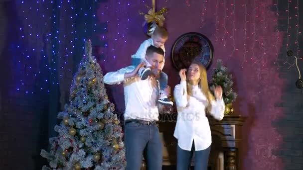 Casal jovem e seu filho fazem uma dança de celebração no Natal . — Vídeo de Stock