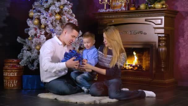 Um menino recebe um pequeno carro de brinquedo como presente de Natal . — Vídeo de Stock