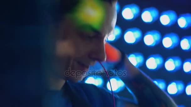 Ein DJ klatscht, nachdem er die Kopfhörer abgenommen hat. — Stockvideo