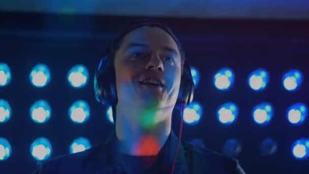 Un DJ heureux sourit et applaudit .