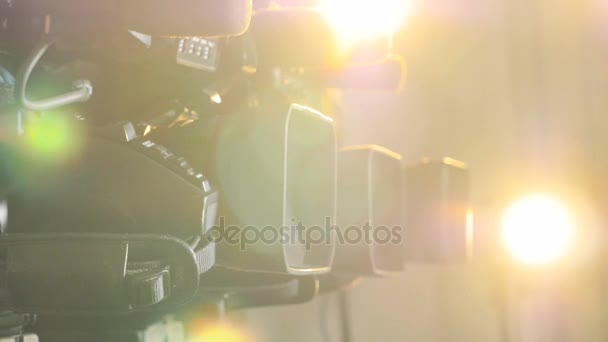 밝고 따뜻한 빛에 초점을 맞춘 여러 가지 다른 비디오 카메라. — 비디오