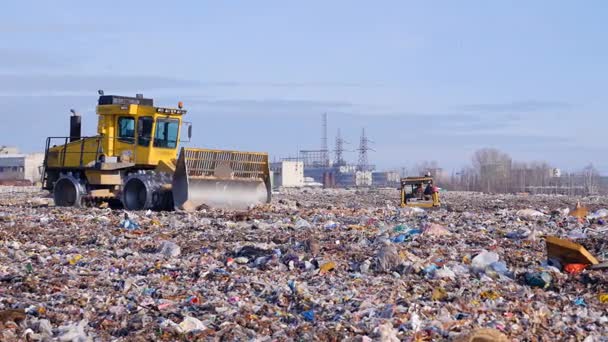 Due compattatori di discarica si muovono attraverso un lato della discarica . — Video Stock