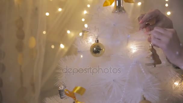 Kvinnliga händer lägga nya dekorationer på en konstgjord julgran. — Stockvideo