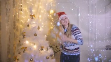 Genç bir kadın bir Noel hediyesi tutarken dans ediyor.