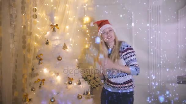 Eine junge Frau tanzt während sie ein Weihnachtsgeschenk in der Hand hält. — Stockvideo