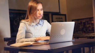 Laptop ve Not Defteri'ni kullanarak notlar kadın yazar. Pencerede yansıyan düşen kar.