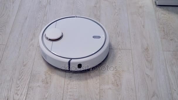A close top view on a robotic vacuum cleaner dusting a corner. — Stock Video