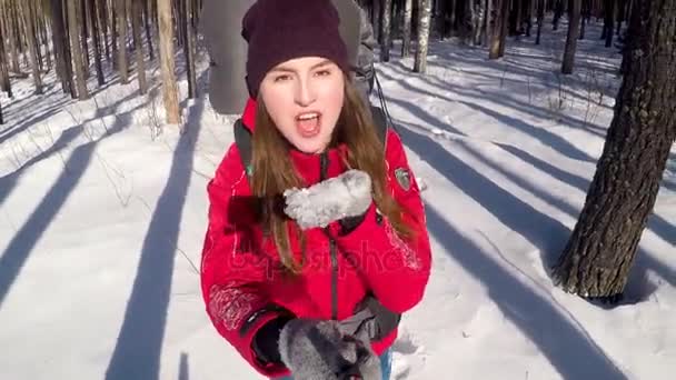 Весела усміхнена позитивна жінка-пішохідка дме сніг з долонь, беручи селфі . — стокове відео