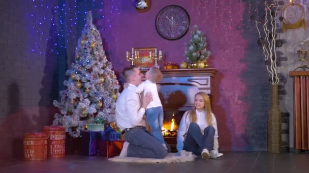 Familia cerca de la chimenea de Navidad. Movimiento lento . — Vídeos de Stock