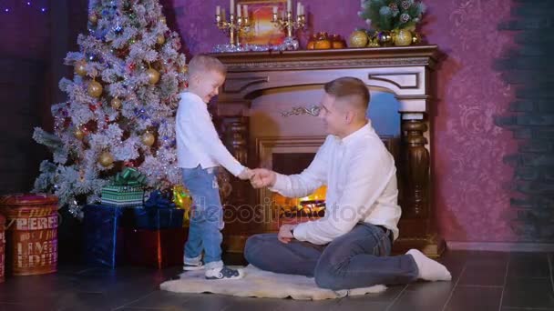 Padre e hijo juegan a divertirse cerca de decoraciones navideñas. HD . — Vídeos de Stock