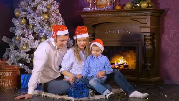 Família feliz abrir presentes de Natal perto de lareira de Natal Ano Novo . — Vídeo de Stock