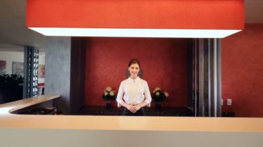 Kız gülümseyerek ve anahtar kart veren resepsiyonda. Otel lobisinde.