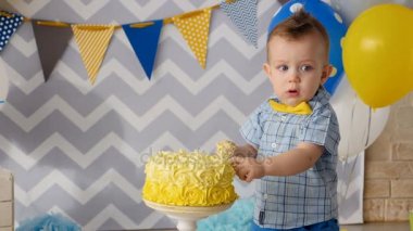 Küçük bir çocuk parmaklarını bir kek içinde sopa.