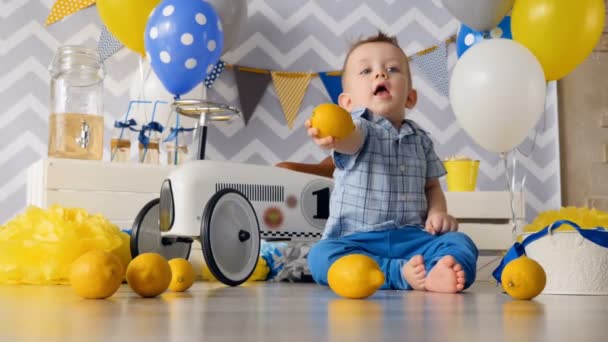 Una vista desde el suelo en un niño pequeño con limones . — Vídeos de Stock