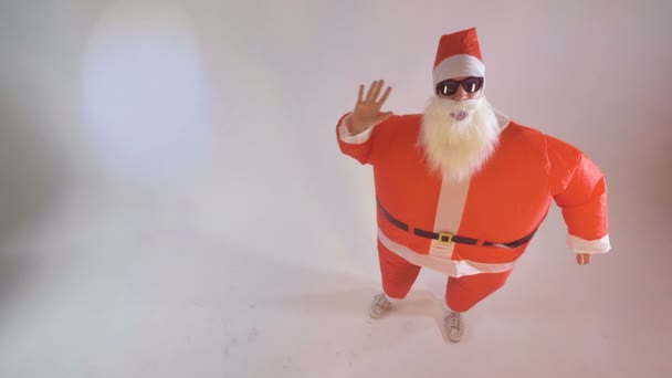 Santa in zonnebril golven langzaam beide handen. — Stockvideo