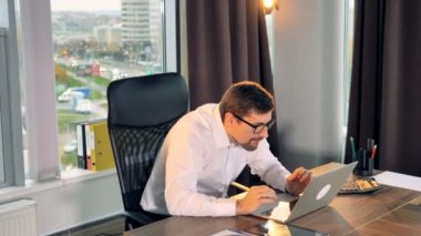 Onun çalışma masasında mutlu bir iş adamı.