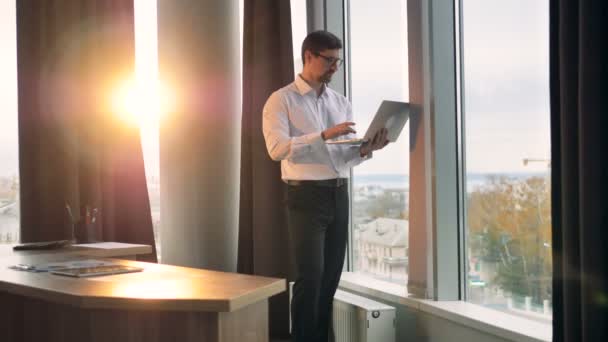 Un homme d'affaires regarde loin dans la distance entre la dactylographie dans le bureau moderne . — Video