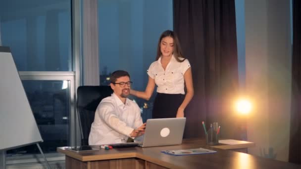 Uma mulher de negócios dá ideias a um homem de negócios com um laptop . — Vídeo de Stock