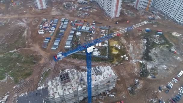 Una cámara girando alrededor de una grúa torre azul en una obra de construcción . — Vídeo de stock