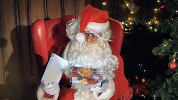 Babbo Natale mettere presnet avvolto in una confezione regalo di Natale. 4K . — Video Stock