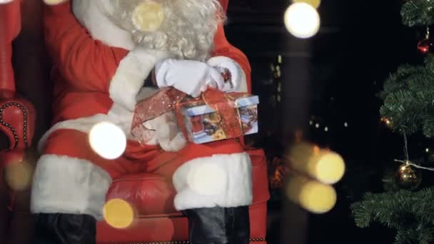 Papai Noel preparando uma caixa de presente. 4K . — Vídeo de Stock