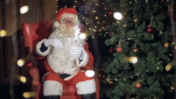 Santa Claus sentado, bailando cerca de la chimenea en la noche de Navidad . — Vídeo de stock