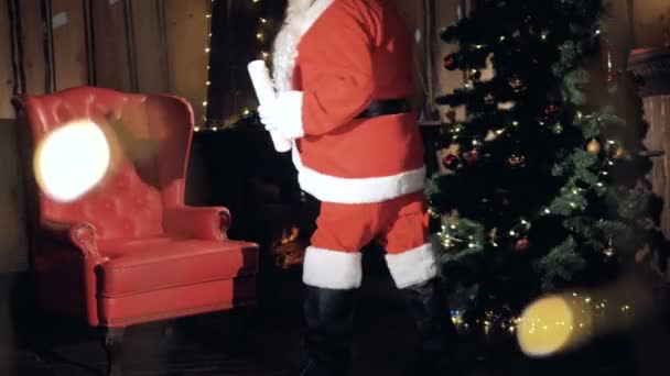 Santa Claus in de buurt van Kerstmis ingericht open haard brieven lezen. — Stockvideo