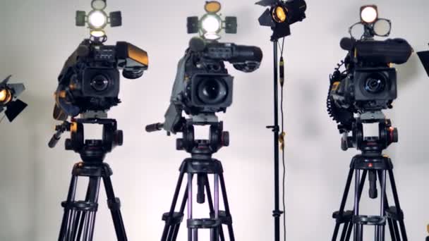 A zooming out shot on three cameras and lighting equipment. — Stock Video