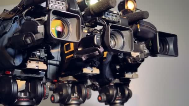 Ein seitliches Vergrößern von drei eingeschalteten Videokameras. — Stockvideo