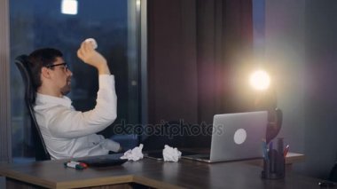Sıkılmış bir işadamı kağıt topları hayal kırıklığı içinde atar..
