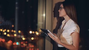 Bir iş kadını bir tablet Pc üzerinde çalışır ve Uzaktan görünüyor.