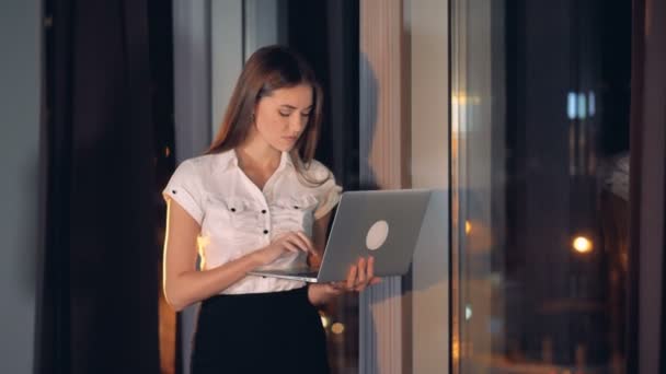 Uma mulher de negócios séria digita em um laptop . — Vídeo de Stock