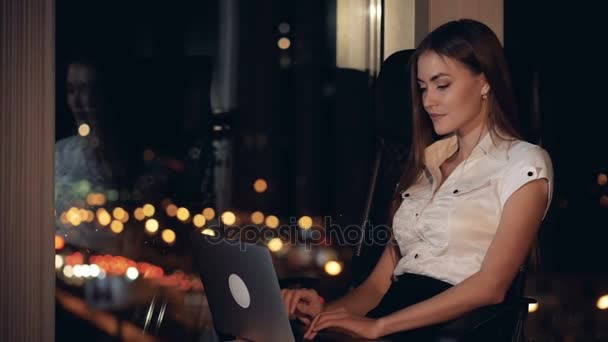 Uma mulher de negócios digita em seu laptop profundamente em pensamento . — Vídeo de Stock