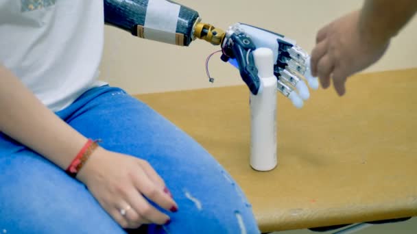 Een gehandicapte vrouw met behulp van robot-assisted bionische arm. — Stockvideo