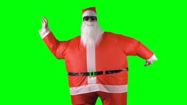 Santa Claus makes arm wave dancing moves on a green background. — Stock Video