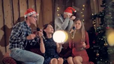 Dört arkadaş şarkı ve şampanya Noel zamanda şarap içmek.