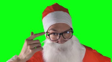 Noel Baba yeşil bir arka plan üzerinde kaşları yükselterek bir yakın çekim.