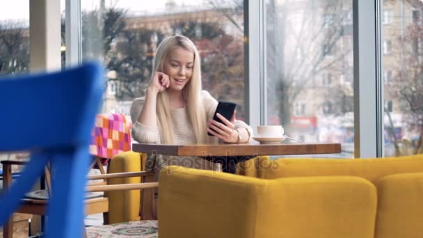 Aantrekkelijke lachende jonge vrouw met behulp van mobiele telefoon. — Stockvideo