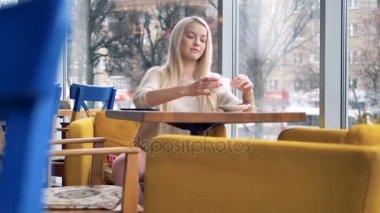 Bir kadın bir kafe pencere oturur ve Nfc ödeme yapar.