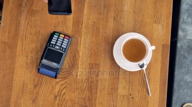 Bir fincan kahve ve bir smartphone bir Nfc ödeme sırasında yukarıdan bir görünüm.