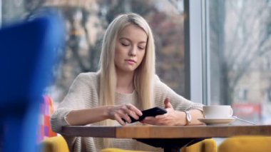 Sarışın kız onun smartphone vasıl baktıktan sonra üzülür.
